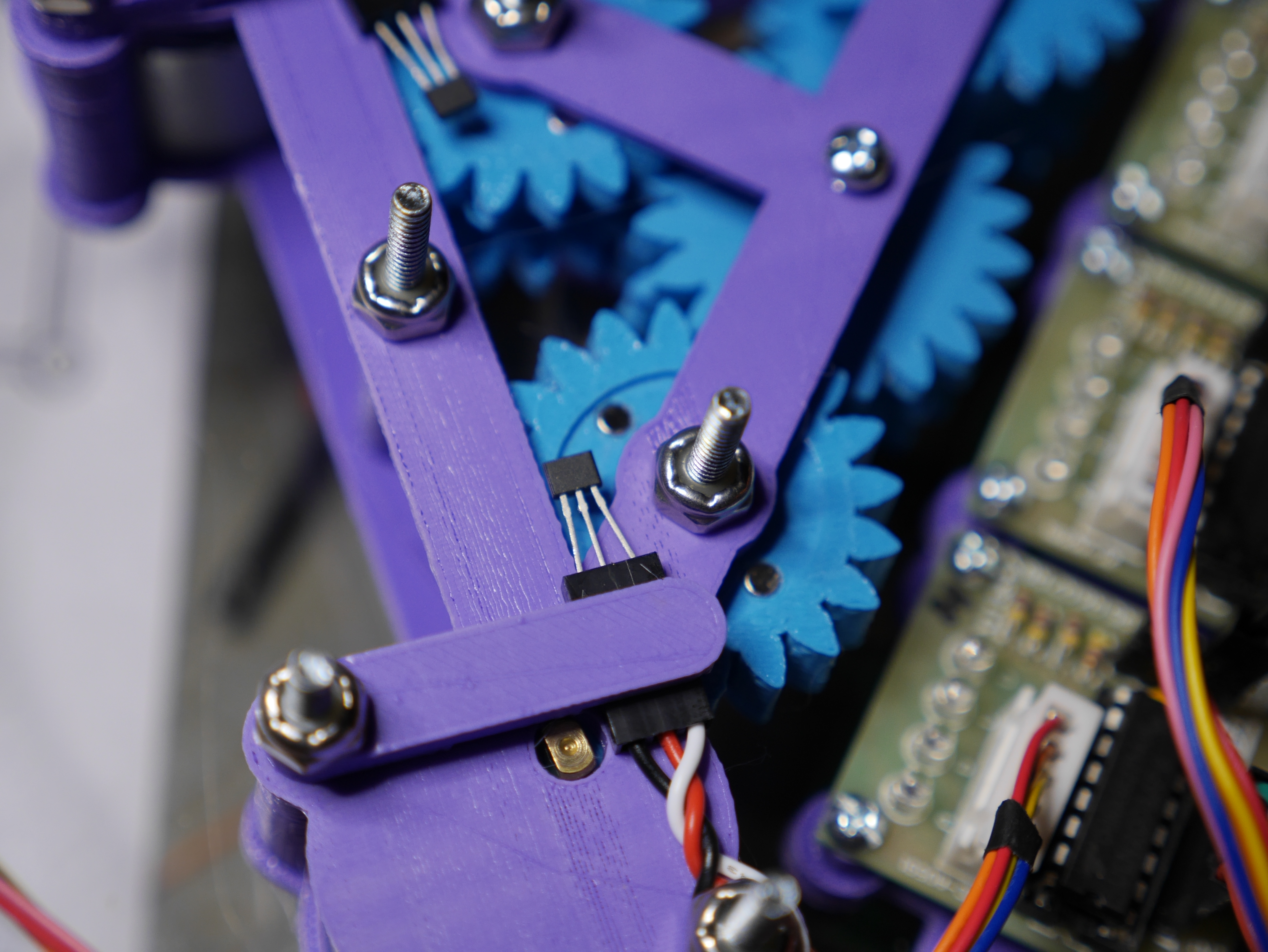 Two magnets on opposite sides of the gear, and the hall effect sensor is clamped just above the gear to detect them.