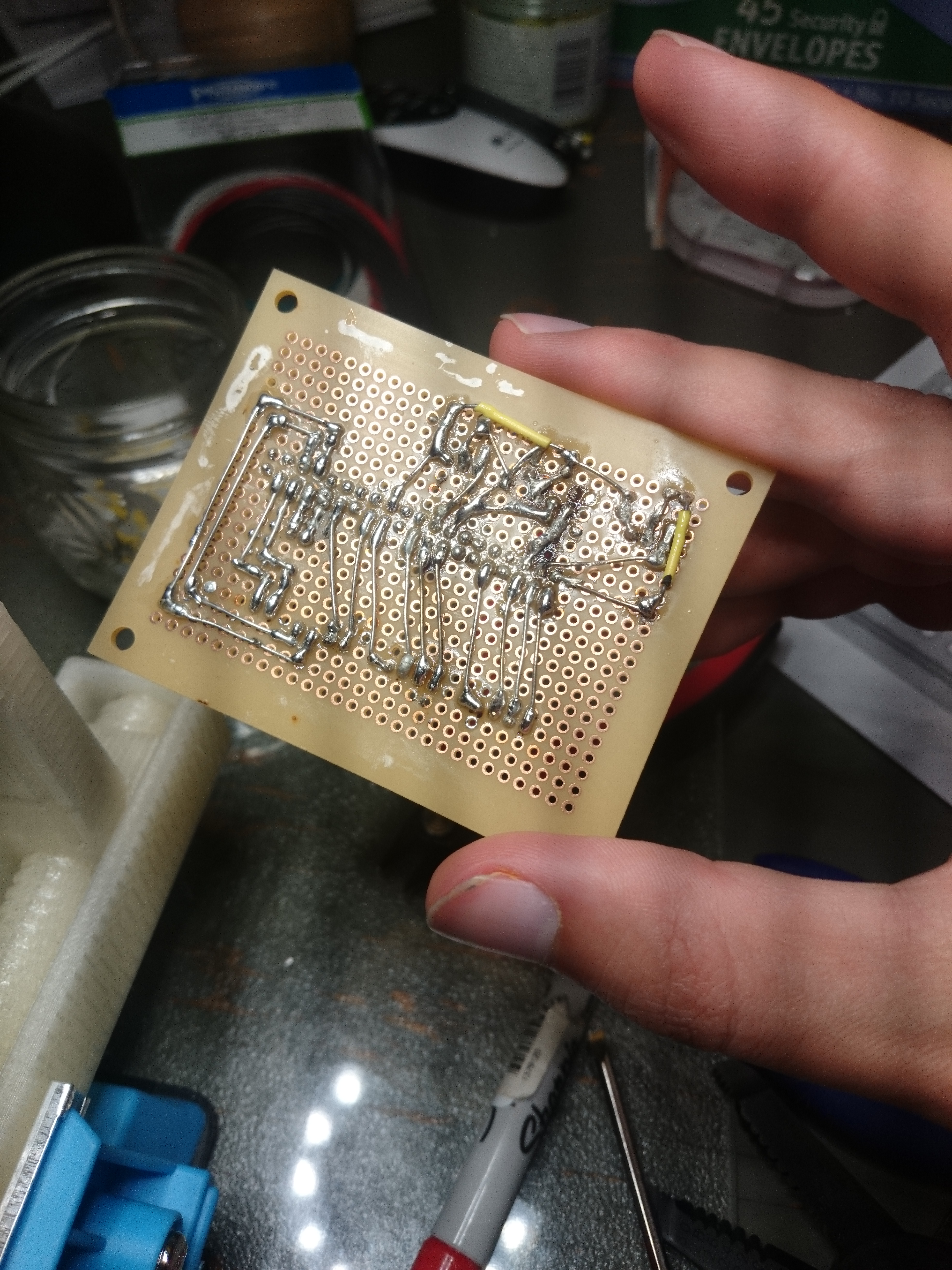 BOttom of perfboard showing a lot of bare wires and soldering.